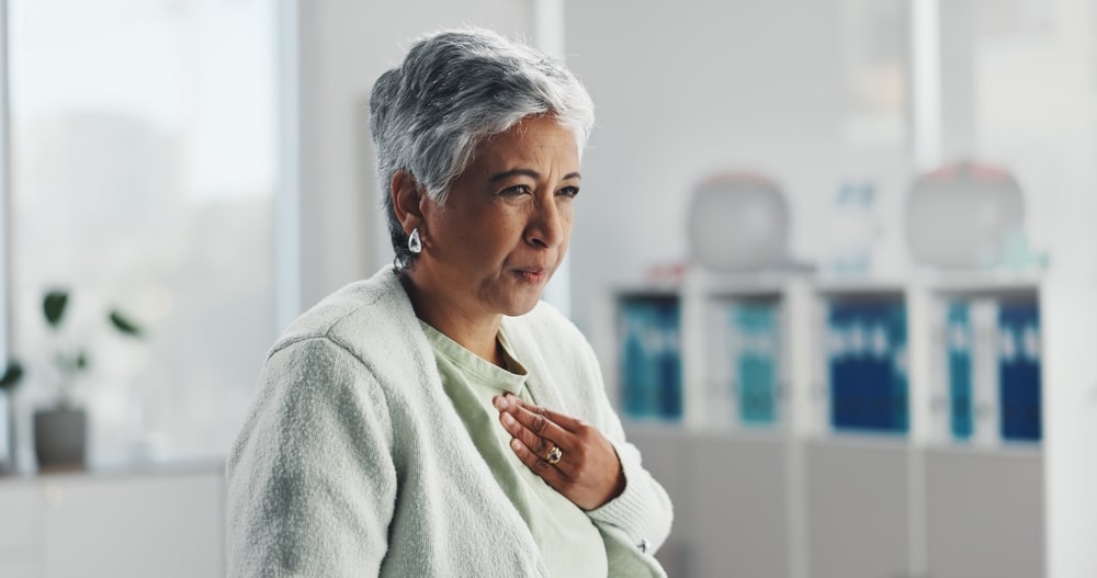 Woman with a hiatal hernia holding her chest