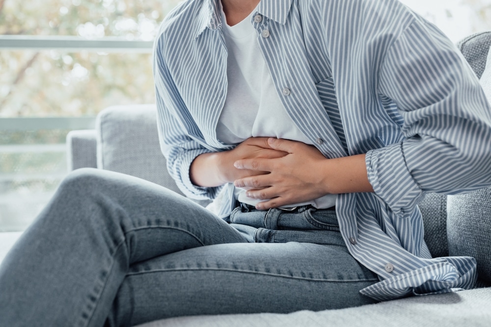 Woman with hernia after abdominal surgery holding her stomach